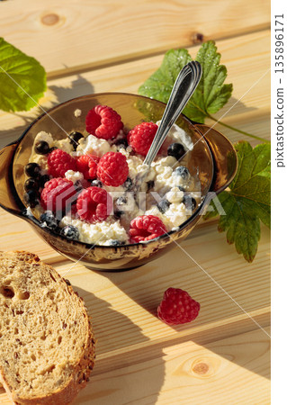 Ricotta or cottage cheese with fresh raspberries and  black currant. 135896171