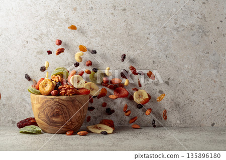 Mix of dried fruits and nuts on a gray stone table. 135896180
