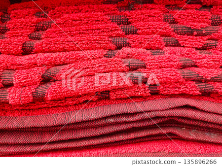 Vibrant Red Textured Woven Floor Mats Stacked Close Up 135896266