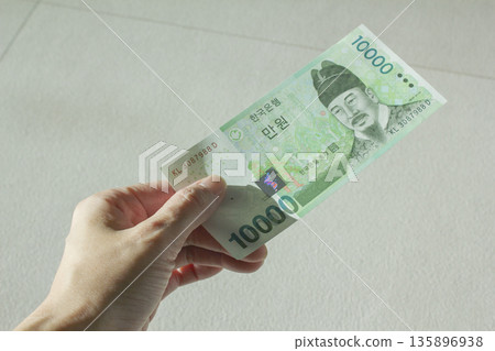 A woman's hand holding ten thousand won 135896938