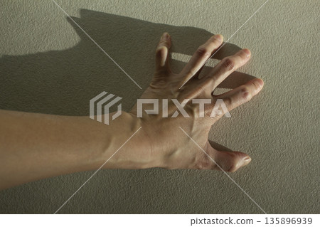 A woman's hand with bulging tendons	 135896939
