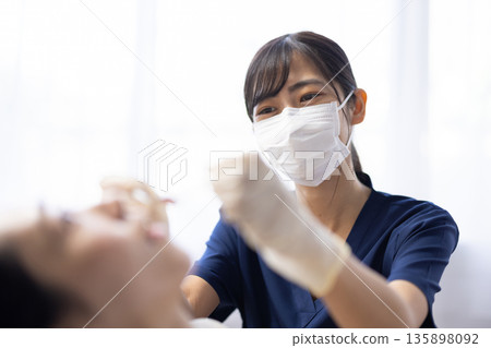 Young dentist woman holding dental instruments to check patient's teeth 135898092