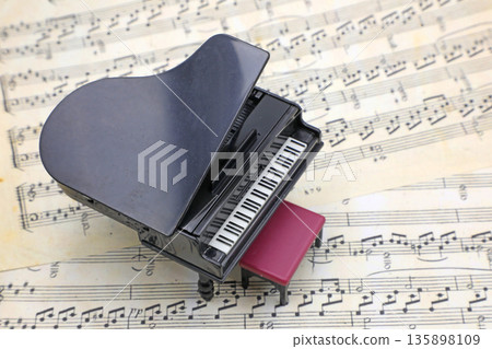 Sheet music and a miniature grand piano Sheet music and a miniature grand piano 135898109