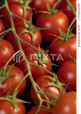 ripe red tomatoes on a black slate board, sweet fresh round tomatoes lie on a black board after harvesting 135898898