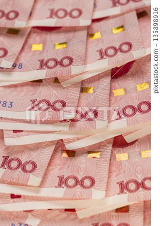 red Chinese cash in denominations of one hundred yuan, heap of paper Chinese banknotes red Chinese cash in denominations of one hundred yuan, heap of paper Chinese banknotes 135898916