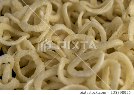 crispy onion rings made from onion puree and flour fried in a large amount of sunflower oil , crispy delicious high-calorie onion rings made from natural ingredients crispy onion rings made from onion puree and flour fried in a large amount of sunflower oil , crispy delicious high-calorie onion rings made from natural ingredients 135898935