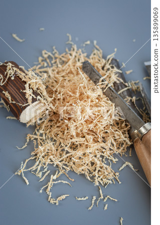 Carpentry tools with wood shavings on gray background Carpentry tools with wood shavings on gray background 135899069