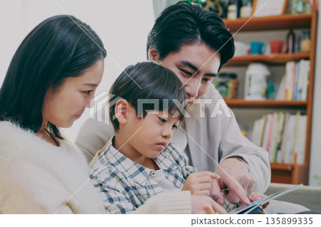 Families reading books in the living room 135899335