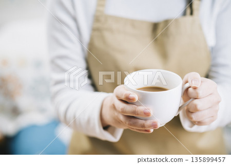 一個女人用一杯咖啡 一個女人用一杯咖啡 135899457
