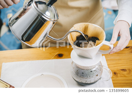 一位女士正在製作滴漏咖啡 一位女士正在製作滴漏咖啡 135899605