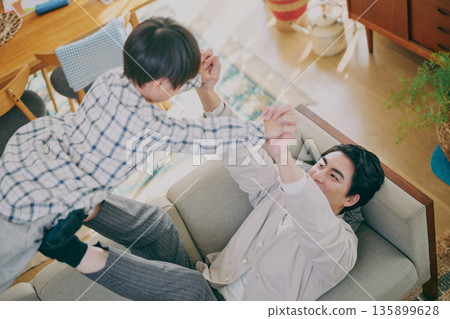 Parent and child playing in the living room 135899628
