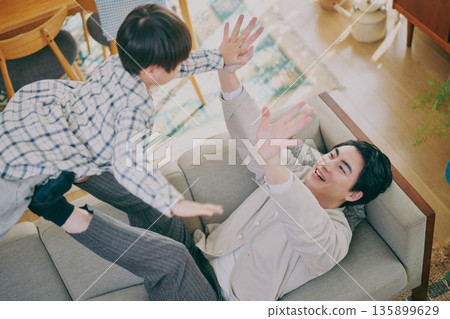 Parent and child playing in the living room Parent and child playing in the living room 135899629