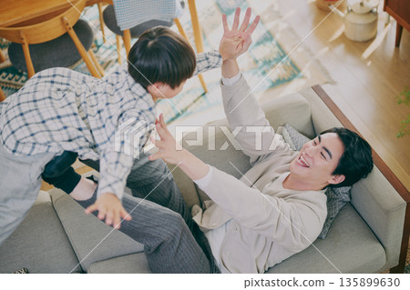 父母和孩子在客廳裡玩 父母和孩子在客廳裡玩 135899630