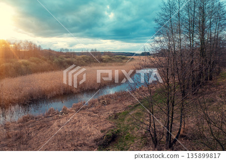 View of the countryside with winding brook and evening sky during sunset. View from above View of the countryside with winding brook and evening sky during sunset. View from above 135899817