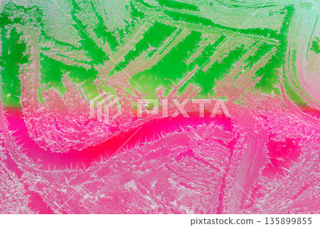 Photo of natural colorful ice texture on the frozen window. Green and pink gradient colors. Abstract background 135899855
