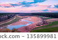 Panoramic view from above of the countryside, winding river, and sky during sunset. Rural landscape in spring 135899981