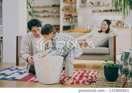 Child and parent folding laundry 135900063