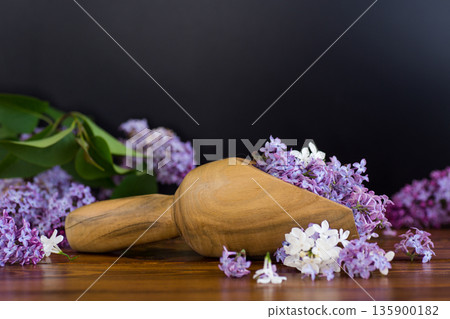 Lilac in a wooden scoop on a black background Lilac in a wooden scoop on a black background 135900182