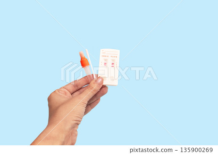 Hand holds a Rapid Antigen Test kit with Negative result during swab COVID-19 testing. 135900269