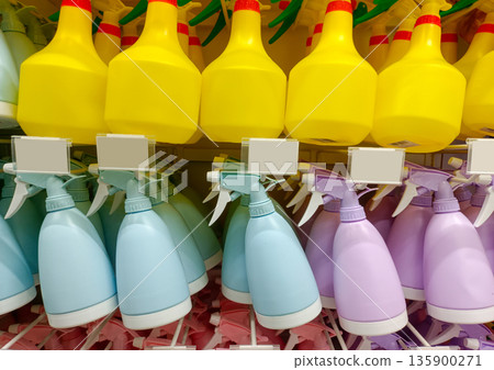 Rows of Plastic Spray Bottles for Gardening and Household Cleaning in Pastel Colors 135900271