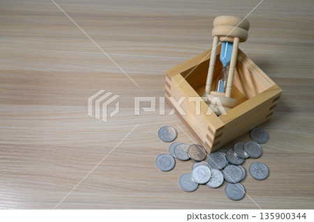 The concept of savings and time represented by a measure, an hourglass, and coins The concept of savings and time represented by a measure, an hourglass, and coins 135900344