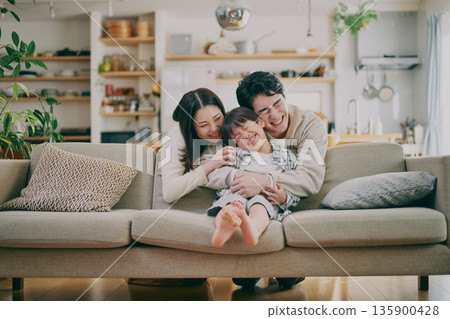 一個家庭在客廳放鬆 135900428
