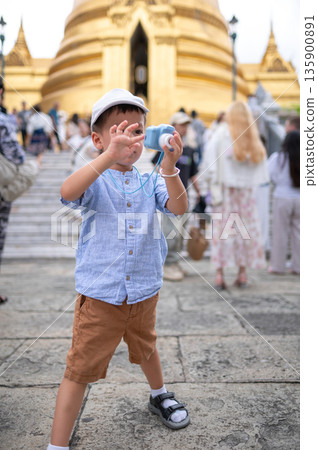 Child Playing With Toy Camera In A Busy Outdoor Setting in Bangkok, Thailand 135900891