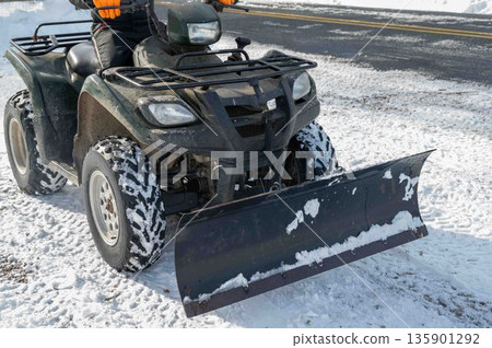 Closeup of the front of a snowplow attached to an off-road vehicle ATV 135901292