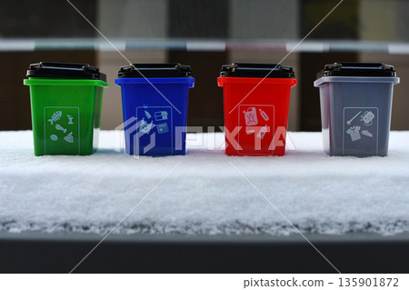 Colorful recycling toy boxes standing in snow, plastic classification trash cans as children's educational toys. Ecology and next generation concept Colorful recycling toy boxes standing in snow, plastic classification trash cans as children's educational toys. Ecology and next generation concept 135901872