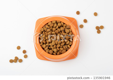 Dry pet food granules in feeding bowl on white background 135901946