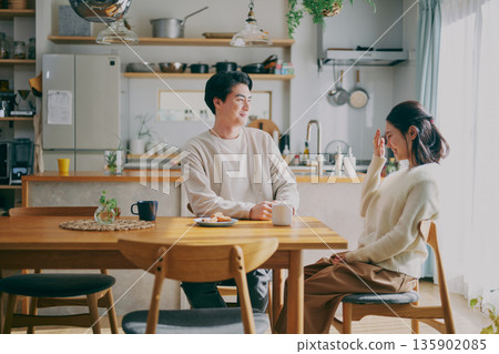 A couple relaxing in the dining room A couple relaxing in the dining room 135902085