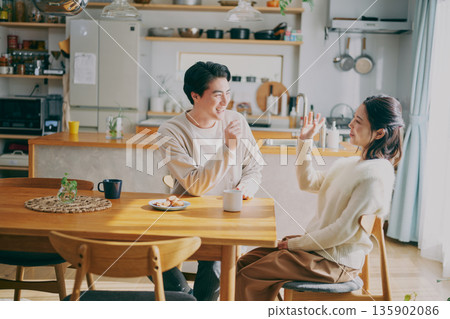 A couple relaxing in the dining room A couple relaxing in the dining room 135902086