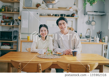 A couple relaxing in the dining room 135902316