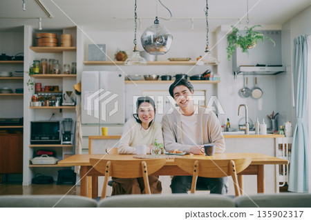 A couple relaxing in the dining room 135902317