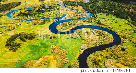 Aerial View Green Forest Woods And River Landscape In Sunny Spring Summer Day. Top View Of Beautiful European Nature From High Attitude In Autumn Season. Drone View. Bird's Eye View Aerial View Green Forest Woods And River Landscape In Sunny Spring Summer Day. Top View Of Beautiful European Nature From High Attitude In Autumn Season. Drone View. Bird's Eye View 135902612