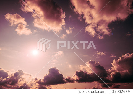 Dramatic Purple Sky with Bright Sun and Towering Clouds Dramatic Purple Sky with Bright Sun and Towering Clouds 135902629
