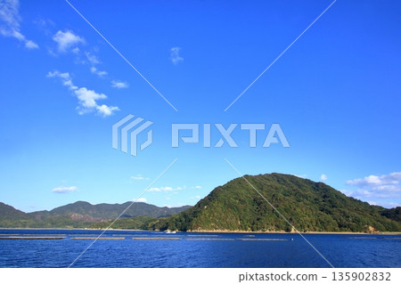 牡蠣筏漂浮在風景如畫的江田島寧靜的景色中,這裡自然資源豐富。 牡蠣筏漂浮在風景如畫的江田島寧靜的景色中,這裡自然資源豐富。 135902832