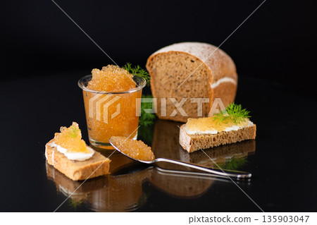 Elegant seafood dish highlighting glossy caviar pearls and smooth spread 135903047