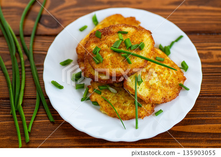 Classic homemade potato pancakes with green onion garnish 135903055