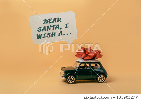 Toy car with a red bow on top of it and a message that says Dear Santa 135903277