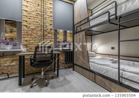 Cozy loft hostel room with bunk beds and night city view Cozy loft hostel room with bunk beds and night city view 135903504