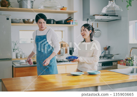 一對夫婦正在收拾碗筷 一對夫婦正在收拾碗筷 135903665