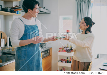 一對夫婦正在收拾碗筷 一對夫婦正在收拾碗筷 135903670