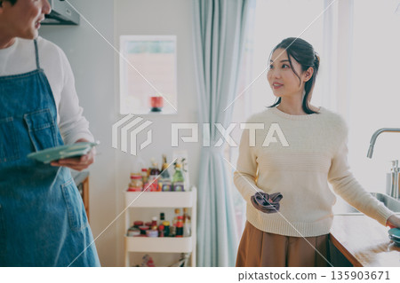 一對夫婦正在收拾碗筷 一對夫婦正在收拾碗筷 135903671