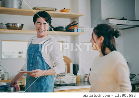 一對夫婦正在收拾碗筷 135903688