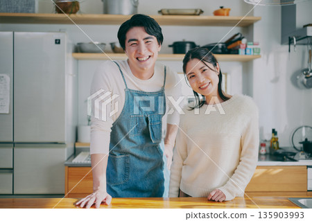 A couple standing in the kitchen 135903993