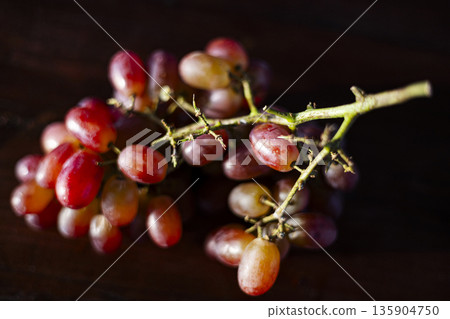 Fresh Grape Bunch On Table, A luscious ad photo of fresh grape bunch on table, dewdrops glistening on plump berries in soft light, perfect for fruit freshness or natural harvest documentary. Fresh Grape Bunch On Table, A luscious ad photo of fresh grape bunch on table, dewdrops glistening on plump berries in soft light, perfect for fruit freshness or natural harvest documentary. 135904750