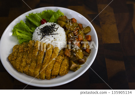 Fried Chicken Curry Rice On A Plate Placed On A Wooden Table, A steaming ad photo of fried chicken , golden chicken over fragrant curry and fluffy rice, perfect for Thai fusion or food documentary. Fried Chicken Curry Rice On A Plate Placed On A Wooden Table, A steaming ad photo of fried chicken , golden chicken over fragrant curry and fluffy rice, perfect for Thai fusion or food documentary. 135905134