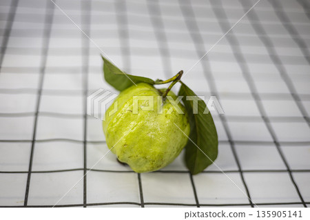 Green Guava In The Bamboo Basket On The Table, A fresh ad photo of green guava in bamboo basket on table, fruits nestled in weave under natural for tropical harvest or rustic produce documentary. Green Guava In The Bamboo Basket On The Table, A fresh ad photo of green guava in bamboo basket on table, fruits nestled in weave under natural for tropical harvest or rustic produce documentary. 135905141