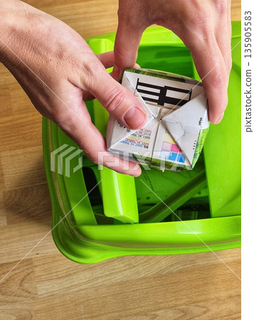 sorting carton packaging (tetra pak) for recycling. hands disposing of empty beverage carton. eco-friendly disposal of drink packaging sorting carton packaging (tetra pak) for recycling. hands disposing of empty beverage carton. eco-friendly disposal of drink packaging 135905583